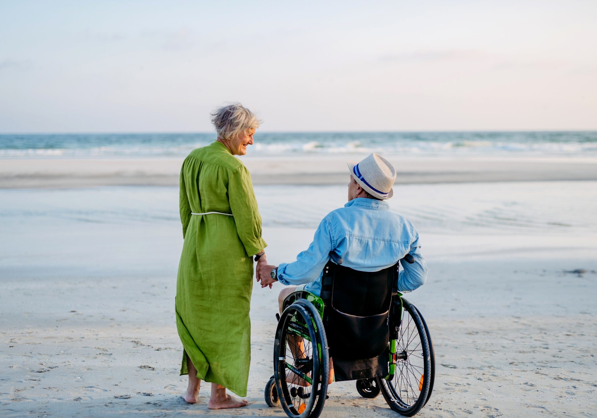 Senior man on wheelchair enjoying together time with his wife at sea. Senior man on wheelchair enjoying together time with his wife at the sea.