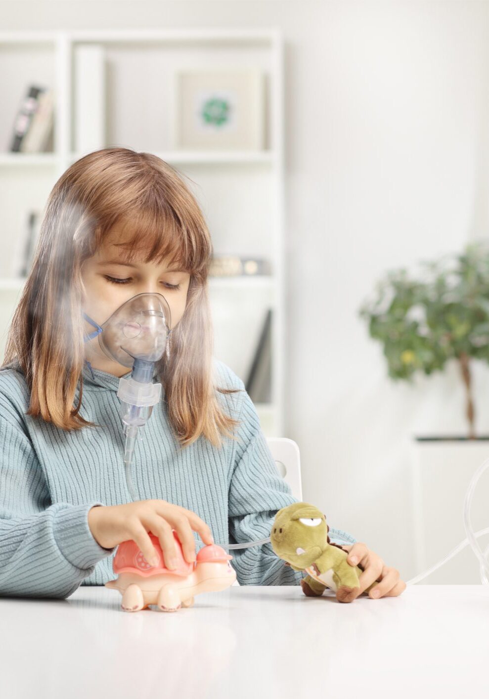 Girl taking a nebulizer treatment Girl taking a nebulizer treatment and playing with her toys